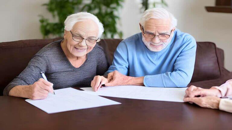 senior couple sign mortgage paperwork